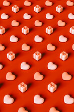  3D Pattern Hearts And Pink Presents On Red Background.