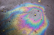 Iridescent spot of gasoline. Petrol on the asphalt a big polluted puddle water. A rainbow slick of gasoline