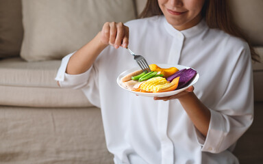 Closeup image of a young woman eating vegetables, Vegan, Clean food, dieting concept