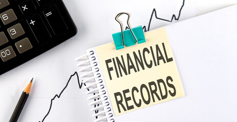 Poster - Stickers with pencils and notebook with text FINANCIAL RECORDS on the wooden background