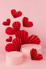 Festive love abstract pink stage mockup for presentation cosmetic product or goods, advertising, design, display with two cylinder podiums, fly red hearts of paper fans in asian style, vertical.