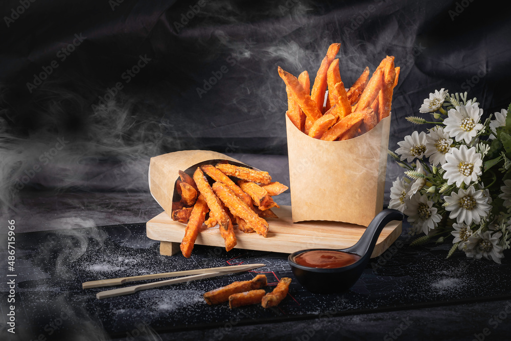 Straight cut is what we commonly see in fast food restaurants. It’s the most popular type. There are various sizes for you to choose so sweet potato fried cooked golden yellow black background smoke