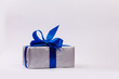 Silver gift box with blue ribbon isolated on white background. Space for text.