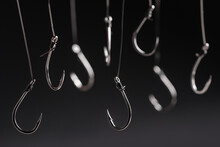 A Fishing Hooks Hanging On A Fishing Line On A Black Background