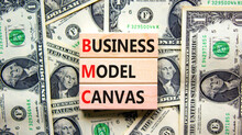 BMC Business Model Canvas Symbol. Concept Words BMC Business Model Canvas On Wooden Blocks On A Beautiful Background From Dollar Bills. Business And BMC Business Model Canvas Concept. Copy Space.