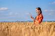 © volody10 - Woman caucasian technologist agronomist with tablet computer in the field of wheat checking quality and growth of crops for agriculture. Agriculture and harvesting concept.