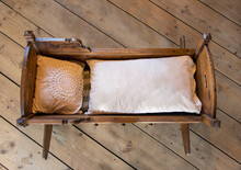 Old Cradle With Duvet And Pillow On The Wooden Floor.