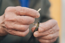 Photo Of The Weathered Hands Of A Craftsman Threading A Rope Through A Bone Needle