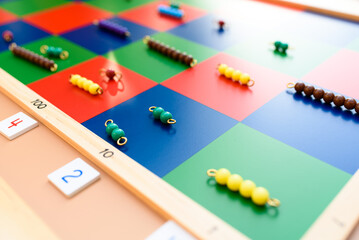 Detail of montessori material, a checker board with tiles and beads.