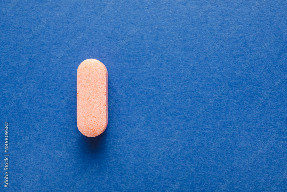 One pill on blue background