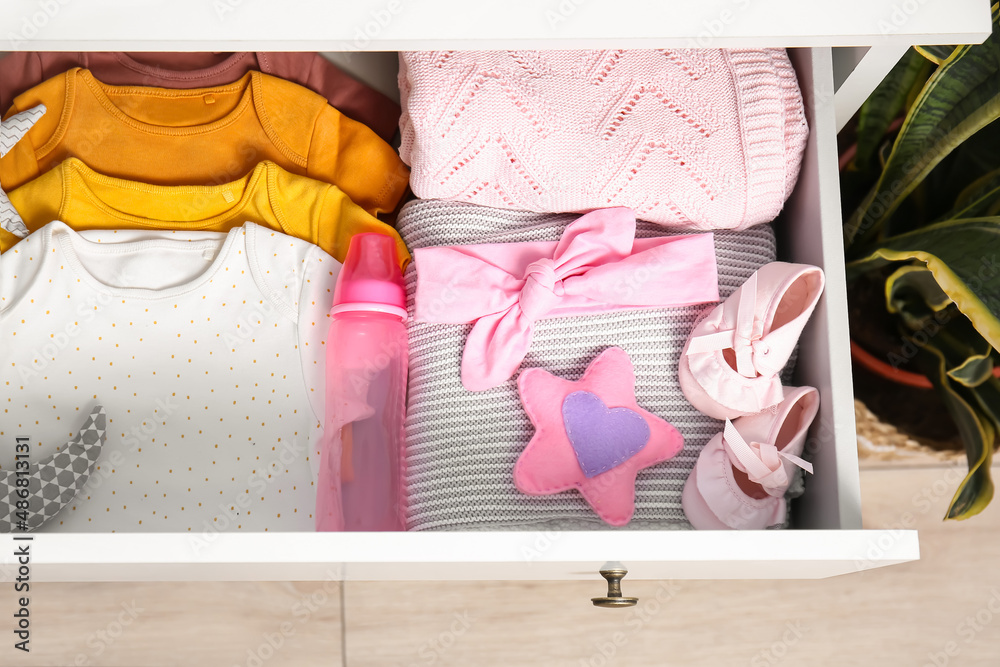 Drawer with baby clothes in children's bedroom