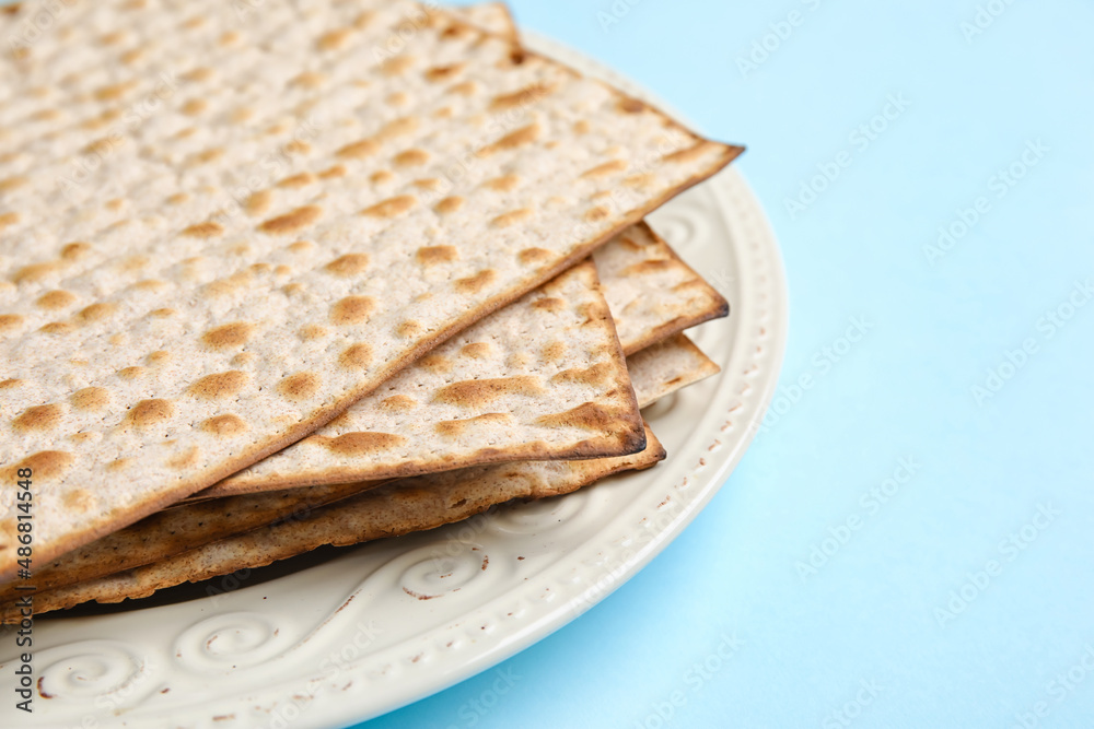 Plate with Jewish flatbread for Passover on color background, closeup