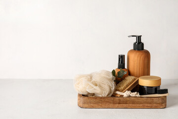 Wooden board with cosmetics and accessories on light background