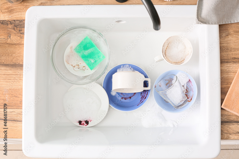 Dirty dishes in ceramic sink