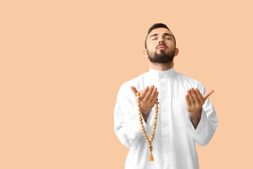 Wall Mural - Praying young Muslim man on color background