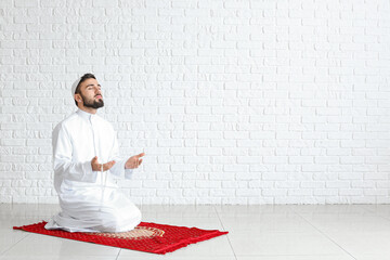 Wall Mural - Praying young Muslim man at home