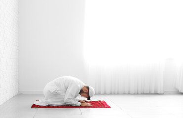 Wall Mural - Praying young Muslim man at home