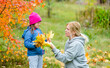 © Ermolaev Alexandr - Woman and little girl with Downs syndrom make a bouquet of autumn leaves