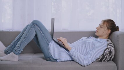 Poster - student lying on sofa using computer