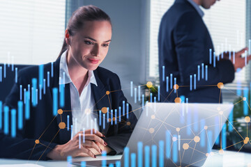 Canvas Print - Smiling attractive businesswoman wearing formal dress working on laptop. financial charts.