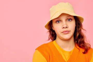 portrait of a young woman in an orange sweater in yellow hat hand gesture cropped view unaltered