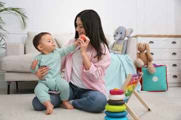 Poster - Cute baby boy playing with mother and toys on floor at home