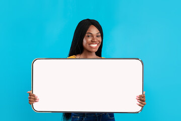 Cheerful black lady showing big white empty smartphone screen