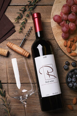 Poster - Bottle of red wine with glass and appetizers on wooden table, flat lay