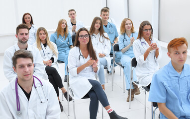 top view. a group of smiling doctors pointing at you.