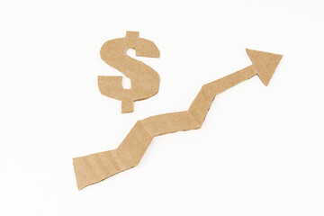 The concept of economic growth. On a white surface, a graph with an up arrow and a dollar symbol.