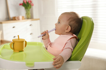 Canvas Print - Cute little baby wearing bib in highchair at home