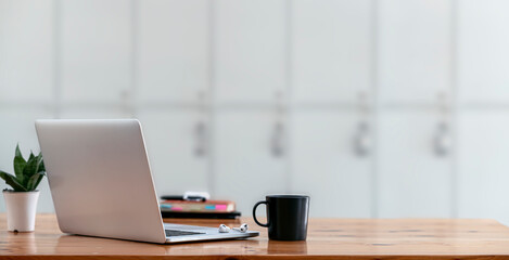 Laptop computer with opened lid on table in modern office room. Creative workspace background concept.