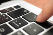 Hand pressing enter key on modern laptop keyboard. Enter sign and symbol close-up