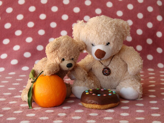 Two small teddy bears choosing doughnut instead of orange. Child unhealthy eating habits concept