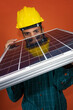 © Andre Nery - Worker With Helmet and Individual Protection Equipment Holding a Solar Photovoltaic Panel isolated.