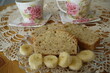 Zbliżenie chleba bananowego z filiżankami herbaty w tle