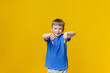 © Aleksandr Uglov - Portrait of caucasian boy showing thumbs down gesture. Dislike, looking at the camera and smiling. Human emotion. Yellow background.