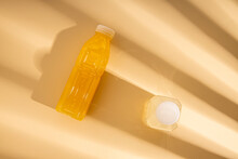 Detox Drink In Plastic Bottles Under The Rays Of The Sun On A Beige Background. Top View Flat Lay.