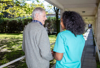 Poster - Caucasian senior smiling with nurse outdoor. Retired elderly people living their life at its best.