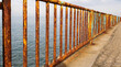 Rusty iron railing, beautiful sea and sky landscape view between oxidized railings gap.