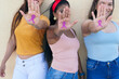 © Hector Pertuz - Group of Latina women showing their hands with a pink ribbon drawing for breast cancer awareness