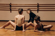© Кирилл Горшков - Portrait of a choreography teacher helping a group of little girls pose correctly in a dance studio with dim lighting. place to copy