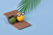 Creative Fun Idea With A Lemon And Lime In Sunglasses Lying On A Sun Bed On A Bright Blue Background. Minimal Travel And Vacation Concept