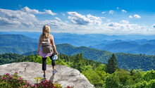 Woman Standing On Top Of The Mountain Relaxing. Girl Hiker Enjoying Summer Mountain Landscape. A Panoramic View Of The Smoky Mountains From The Blue Ridge Parkway, North Carolina. Near Asheville.