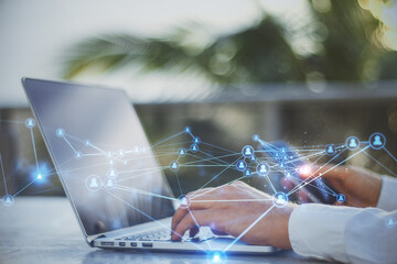 Poster - Close up of businessman hands at desktop using laptop and smartphone with abstract glowing polygonal network with people icons. Blurry background. 