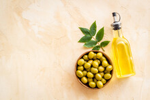 Bottle Of Olive Cooking Oil With Green Olives In Bowl
