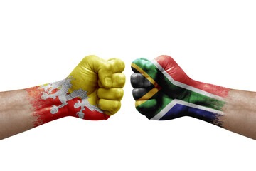 Two hands punch to each others on white background. Country flags painted fists, conflict crisis concept between bhutan and south africa