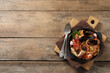 Delicious spaghetti with seafood served on wooden table, top view. Space for text