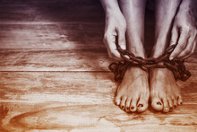 Close Up Of A Woman Hands Holding Metal Chain At Her Legs Sitting On The Wooden Floor, Conceptual  Image, Vintage Sepia Tone With Copy Space