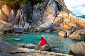 Wall Mural - Tourist sitting on the rock near Grandfather and grandfather rock (Hin Ta and Hin Yai Rocks) on the Lamai Beach, Koh Samui, Thailand.